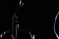 A silhouette of a person with their index finger at their lips indicating quiet.
